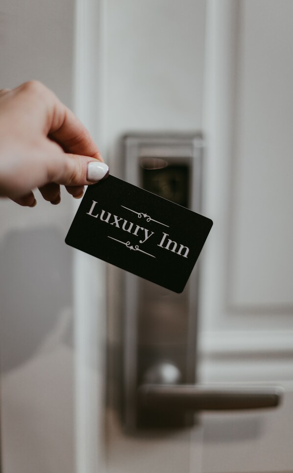 A hand holding a black card with "Luxury Inn" written on it.