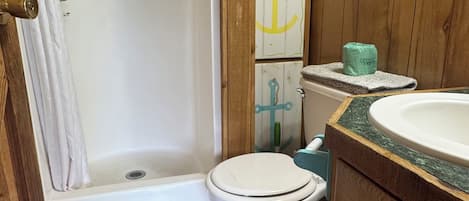 Ein Badezimmer mit Dusche, Toilette und Waschbecken.