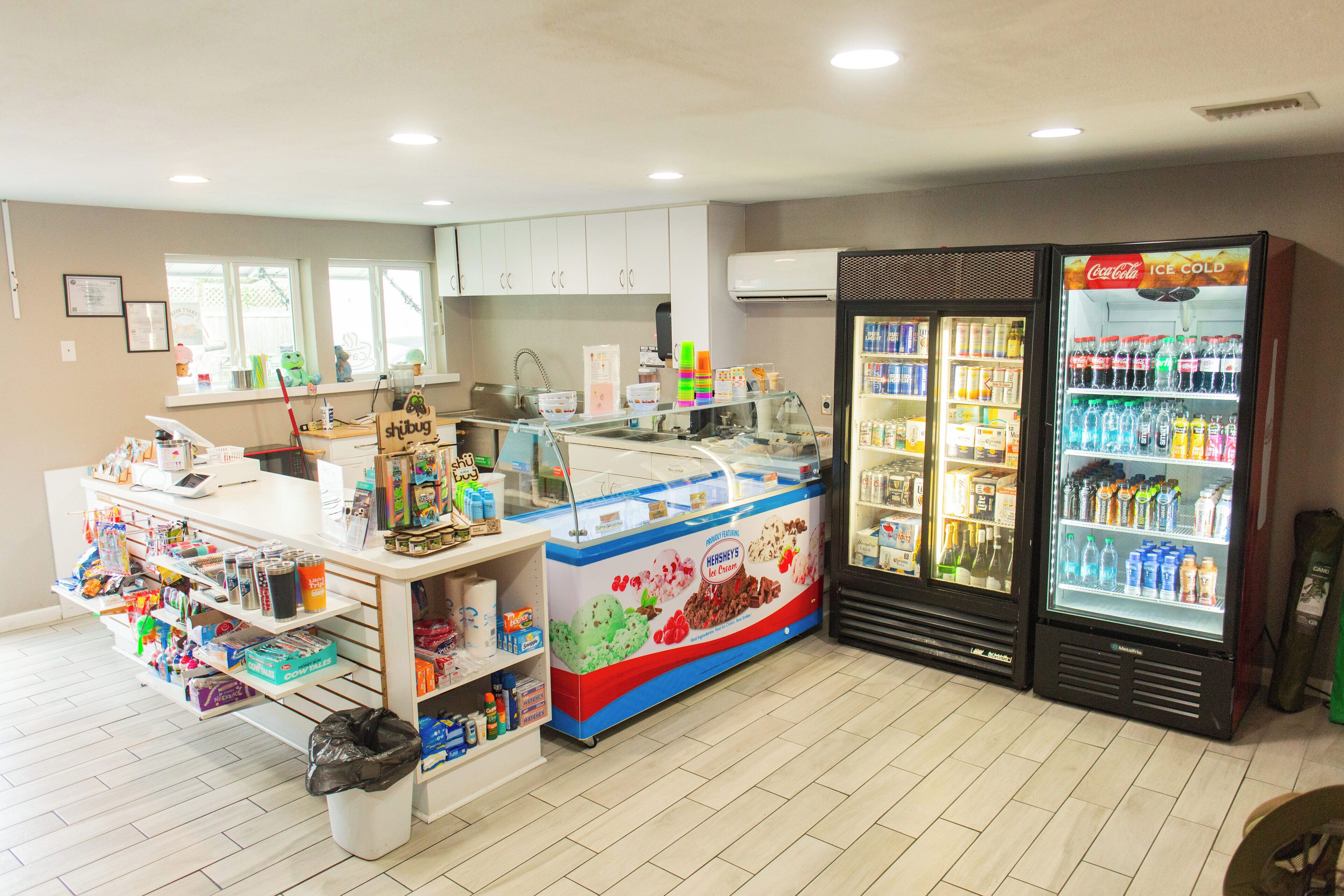 Ein kleiner Eisladen mit verschiedenen Geschmacksrichtungen und einem Coca-Cola-Kühlschrank.