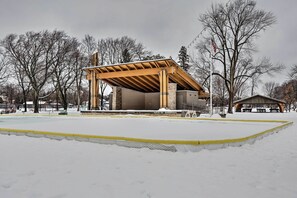 Ein überdachter Außenbereich mit Holzkonstruktion, möglicherweise ein Pavillon, umgeben von Schnee.