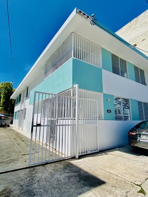 Two-story building with a gated entrance and large windows.