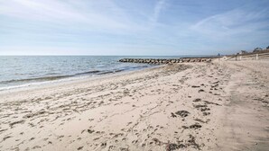 A sandy beach with a rocky breakwater and a clear sky. - Walk to Haigis Beach: Cape Cod Retreat w/ Deck! (Dennis)