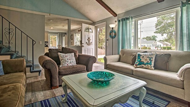 A living room with two sofas, a coffee table, and a staircase. - Walk to Haigis Beach: Cape Cod Retreat w/ Deck! (Dennis)
