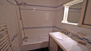 Ein Badezimmer mit Badewanne, Waschbecken und Dusche.