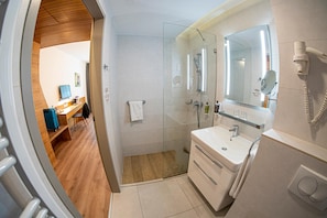 A modern bathroom with a shower, a sink, and a mirror.