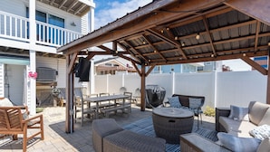 An outdoor patio with wicker furniture, a covered seating area, and a pool. - Renovated with Backyard Oasis! Quick Walk to Town & Beach. 4 BRs. Sleeps 10 (Sea Isle City)