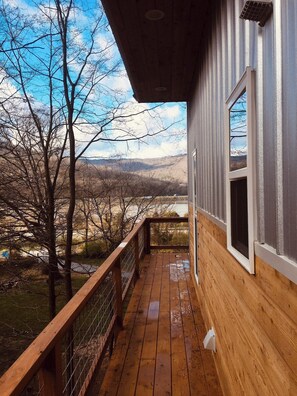 A wooden deck with a metal railing overlooking a mountainous landscape. - Blue Heron Treehouse - Private Hot Tub (Guild)