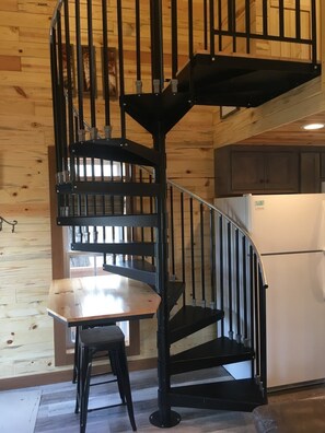 A spiral staircase with a wooden interior and a metal railing. - Blue Heron Treehouse - Private Hot Tub (Guild)