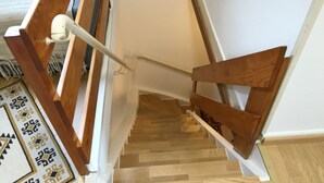 Un escalier en bois avec des rampes et une main courante blanches.