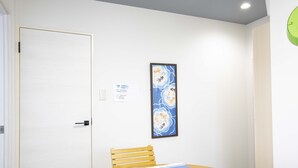 Una habitación con una mesa de madera, una silla, una obra de arte enmarcada en la pared y una puerta.