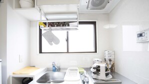 Una cocina con un lavamanos de acero inoxidable, una ventana con marco negro y un horno empotrado.