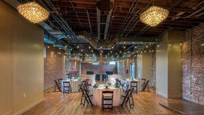 A spacious hall with wooden flooring, round tables set for dining, and hanging industrial-style chandeliers. - The Sessions Hotel, Bristol, a Tribute Portfolio Hotel (Bristol)