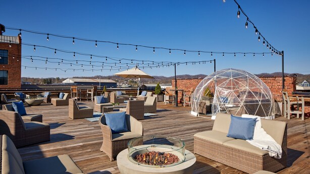 A rooftop patio with outdoor furniture, a fire pit, string lights, and a greenhouse structure. - The Sessions Hotel, Bristol, a Tribute Portfolio Hotel (Bristol)
