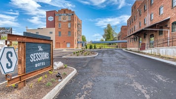 A hotel entrance with a sign reading "The Sessions Hotel" and a large building labeled "Southern Craft Sessions" in the background.