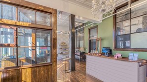 A reception area with wooden paneling, a reception desk, and a chandelier. - The Sessions Hotel, Bristol, a Tribute Portfolio Hotel (Bristol)