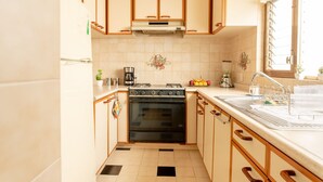 A compact kitchen with a stove, sink, and a window.