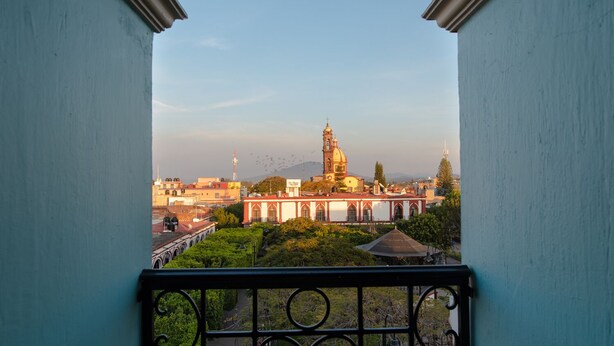 A balcony with a view of a church and surrounding buildings.