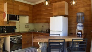 Une cuisine moderne dotée de meubles en bois, d’un four encastré, d’un four à micro-ondes et d’un distributeur d’eau.
