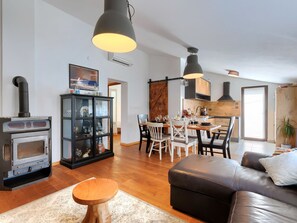 A modern living room with a fireplace, dining area, and kitchen. - Barbolan by Interhome (Medulin)