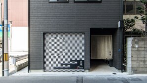 Un edificio moderno de dos pisos con entrada de garaje y un diseño a cuadros en la puerta.