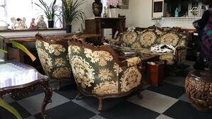Una sala de estar con piso a cuadros, un conjunto de sofás, una mesita de centro y una mesita auxiliar.