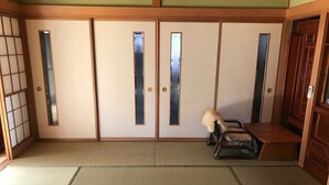 Una habitación japonesa tradicional con suelo de tatami, puertas correderas y un banco de madera.