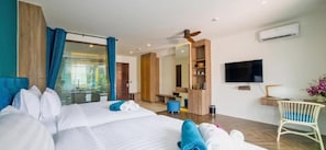 A hotel room with a large bed, a desk, a chair, a television, and a mirror.