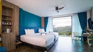 Una habitación de hotel con una cama grande, un escritorio y vistas al exterior.