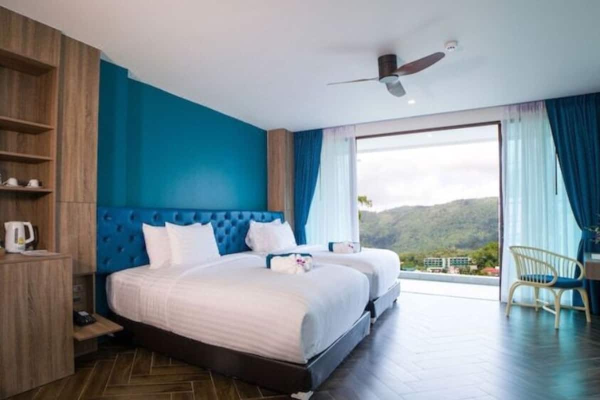 Une chambre d’hôtel avec un grand lit, un bureau et une vue sur l’extérieur.