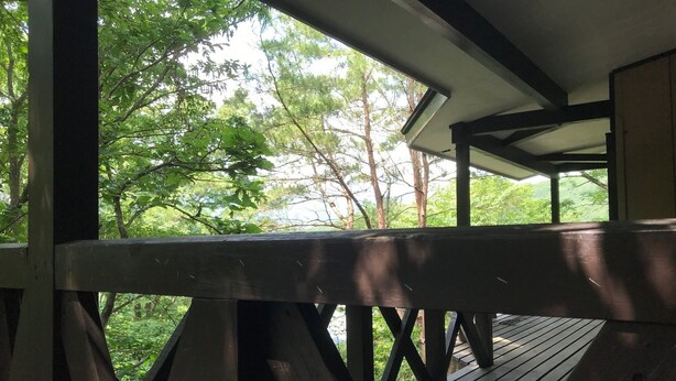 A wooden deck with a view of lush green trees. - Nasukogen Holiday (Nasu)