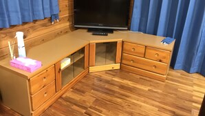 A corner room with a wooden desk, a television, and a blue curtain. - Nasukogen Holiday (Nasu)