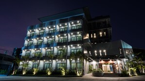 A multi-story hotel with balconies and a well-lit entrance. - Little Loft Hotel (Wichit)
