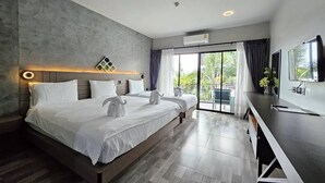 A modern bedroom with a large bed, a flat-screen TV, and a sliding glass door leading to a balcony. - Little Loft Hotel (Wichit)