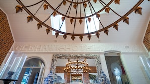 A hotel interior with a large chandelier, a mirror with a decorative frame, and blue and white patterned vases. - The Eaglehawk Country House Hotel Maldon (Maldon)