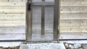 A wooden door with a peephole and a mailbox on the wall. - Nasu Holiday (Nasu)