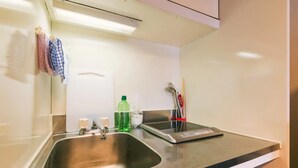 Eine moderne Küche mit einer Edelstahlspüle, einer digitalen Waage und einer Flasche Spülmittel.