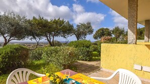A table set outdoors with a view of trees and the sea.