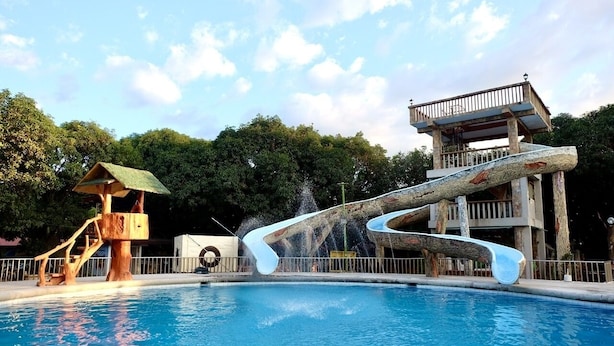 A swimming pool with a water slide and a wooden structure. - Casa Virginia Resort (San Narciso)