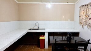 A compact kitchen with a sink, a dining table, and chairs. - Casa Virginia Resort (San Narciso)