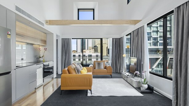Un apartamento moderno con cocina, sala de estar y ventanas amplias que ofrecen vistas a la ciudad.