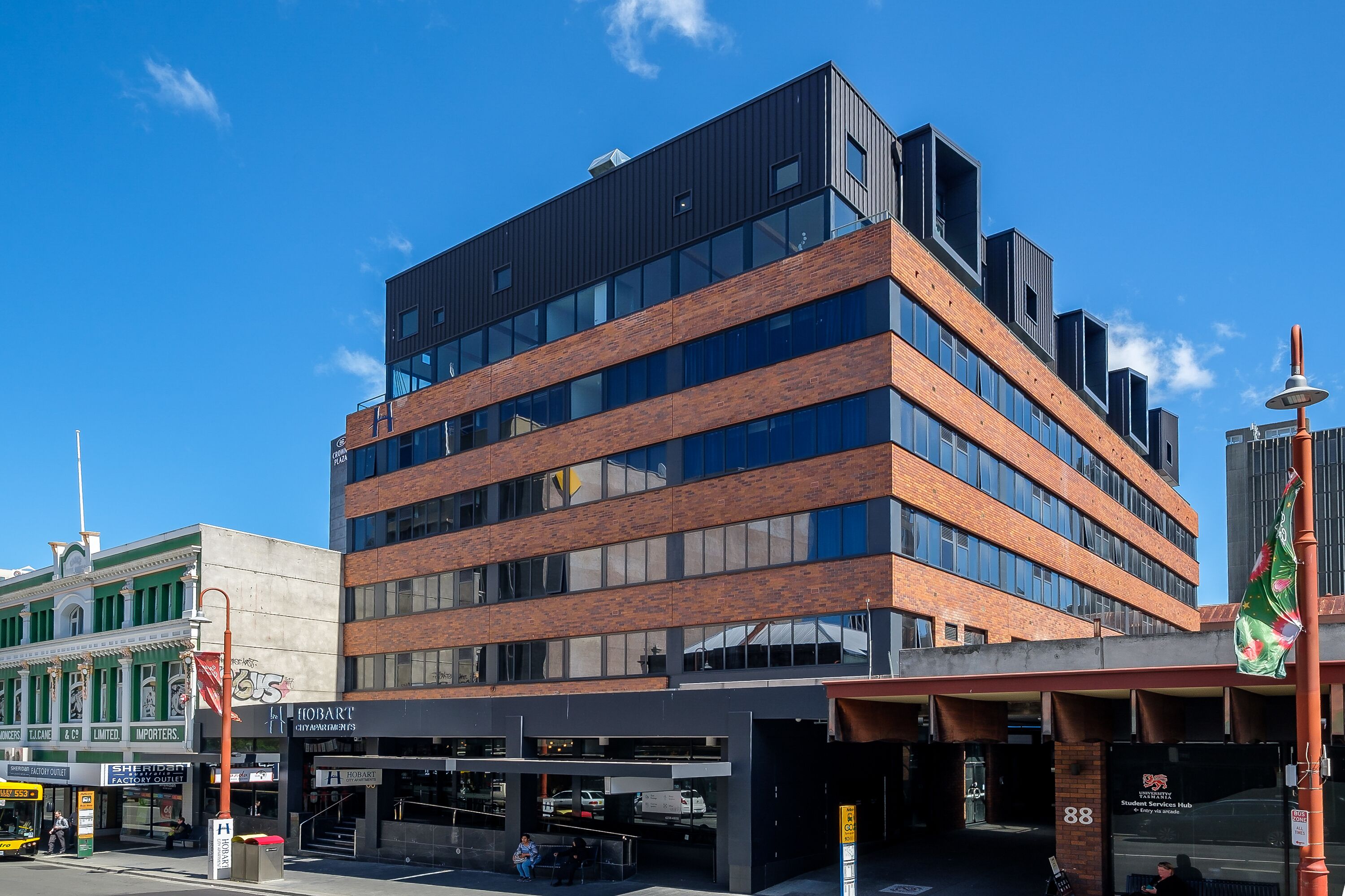 A multi-story building with a modern architectural design, featuring a mix of brick and glass facades.