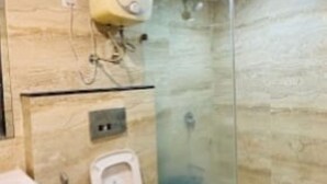 Un baño con inodoro, lavamanos y cabina de ducha de vidrio.