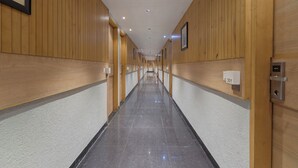 Un pasillo largo y estrecho con paneles de madera en las paredes y suelo de baldosas.