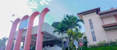 Un edificio moderno con un arco rosado y un letrero que dice "AMANDA SULLY".