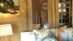 A bedroom with a bed, a nightstand, a lamp, a painting, a chandelier, and a wardrobe. - Affi Lande Boetiek Guest Farm (Fouriesburg)