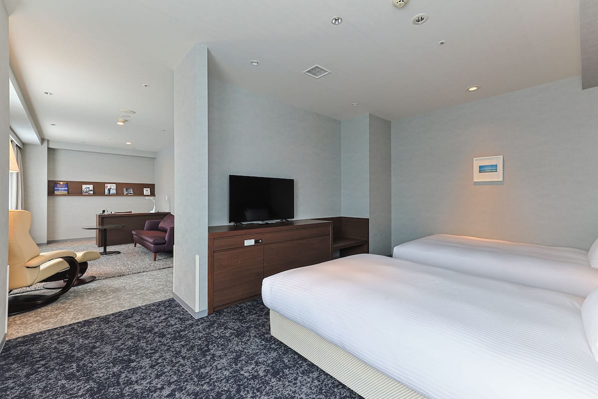 Une chambre d’hôtel avec un lit, une télévision, un bureau et une chaise.