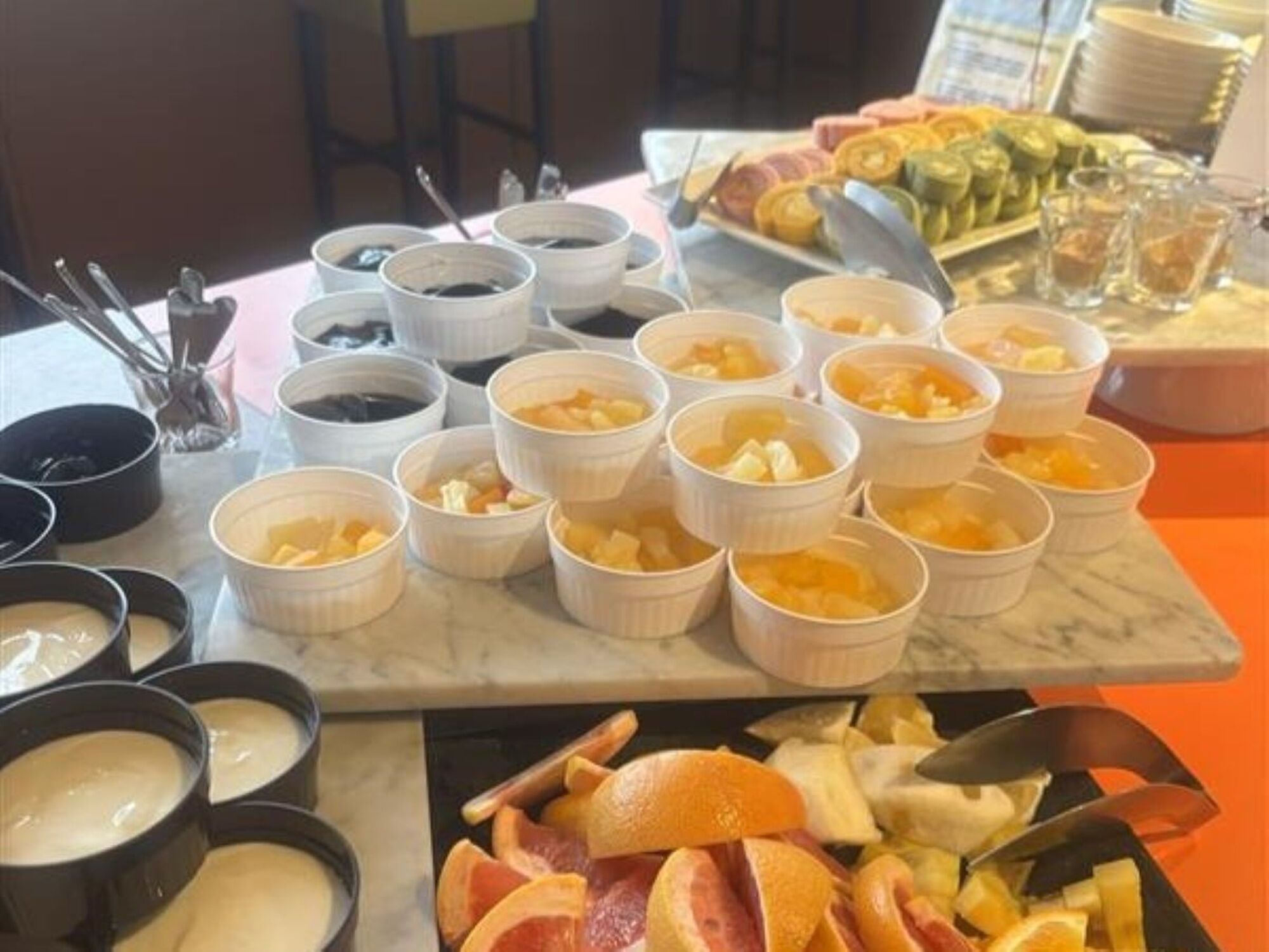 Uma mesa de buffet com diversos alimentos e recipientes.