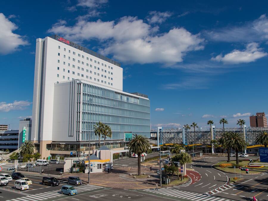 A modern hotel with a large glass facade, multiple floors, and a prominent sign at the top.