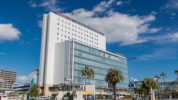 A modern hotel with a prominent white facade and multiple floors.