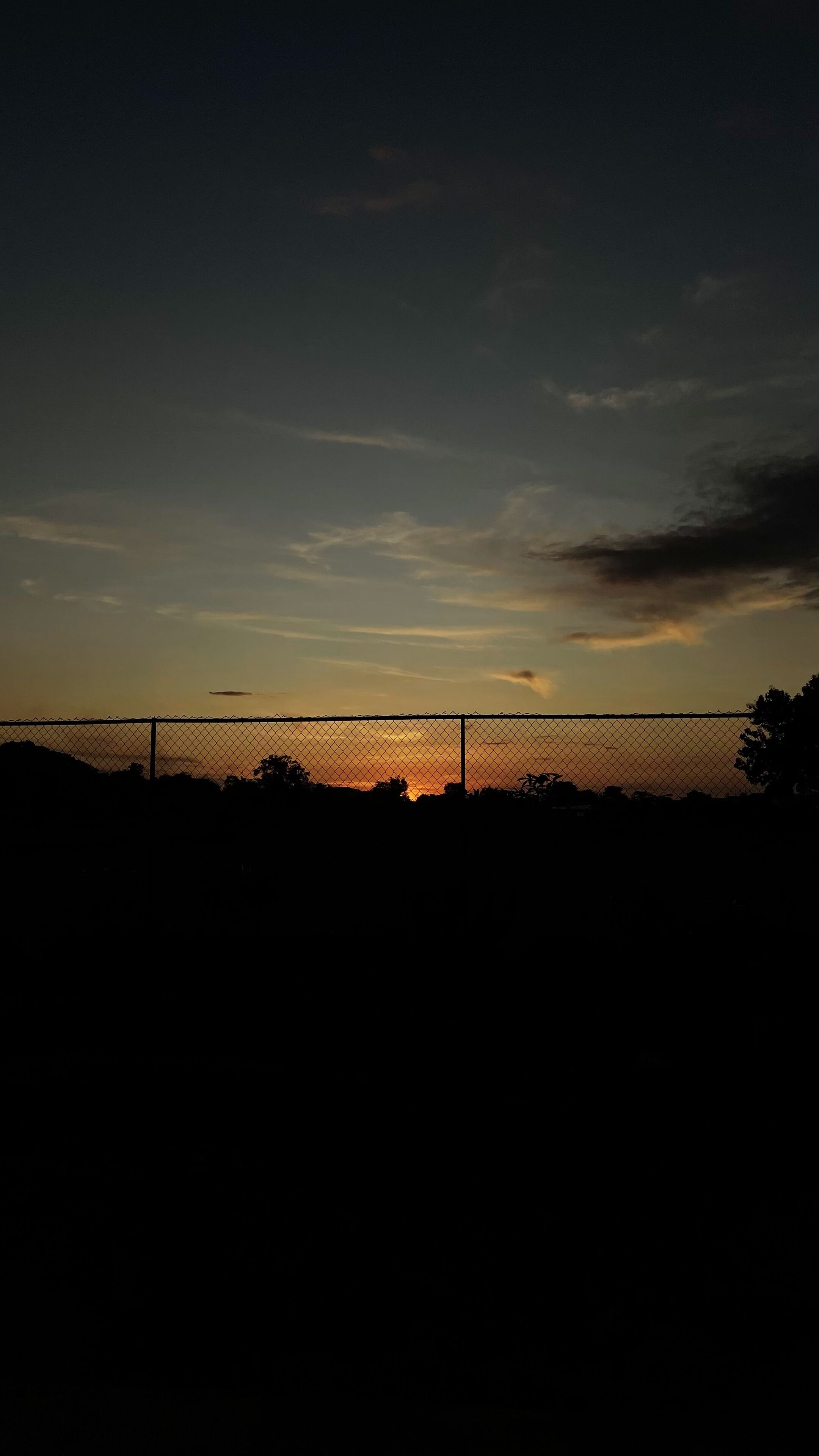 A fence with a sunset in the background.
